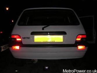 rover metro with twin rear fog lamps lit up at night 